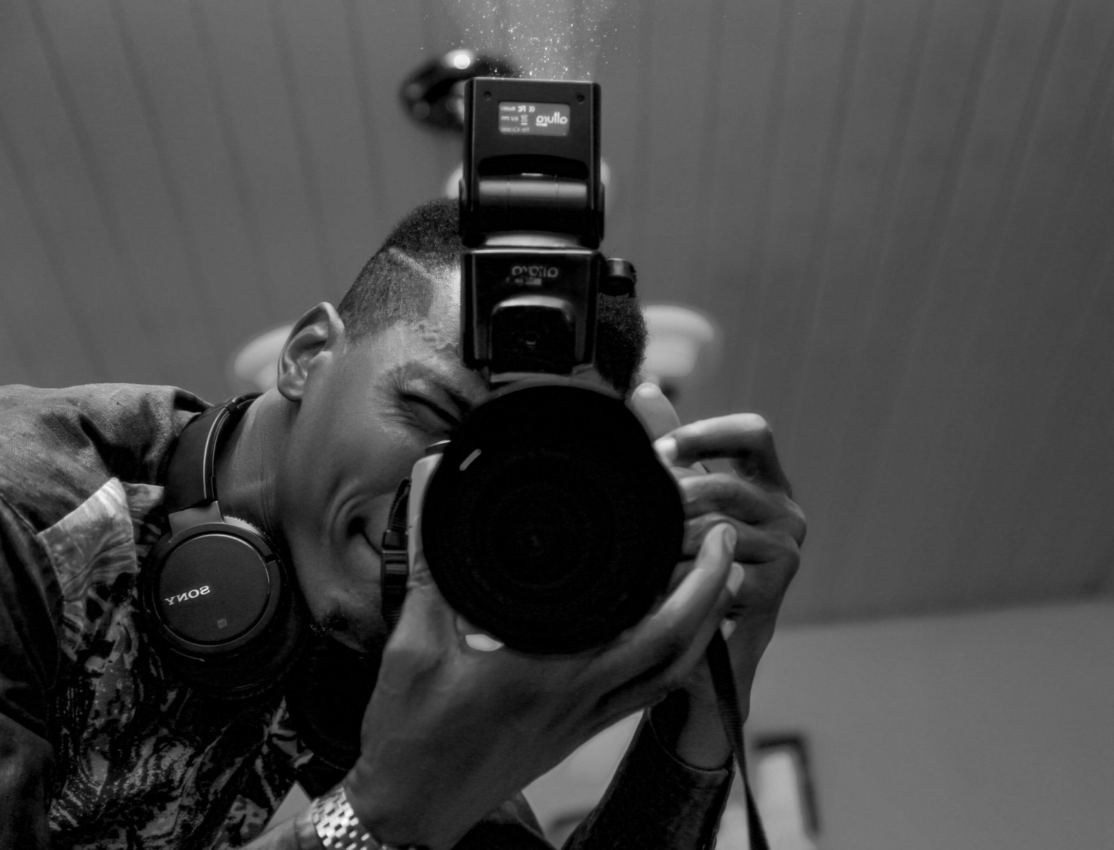 Monochrome close-up of a photographer in action, capturing the moment with a professional camera.